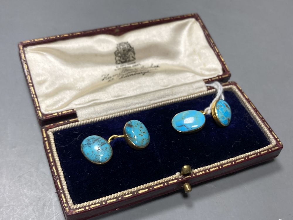 A pair of yellow metal and oval turquoise cabochon set cufflinks, stone length approx. 12mm, gross 6.1 grams,